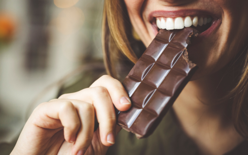 donna che morde una tavoletta di cioccolato